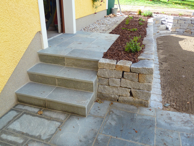 Hauszugang mit Granitsteinmauer und Stufen zur Haustüre